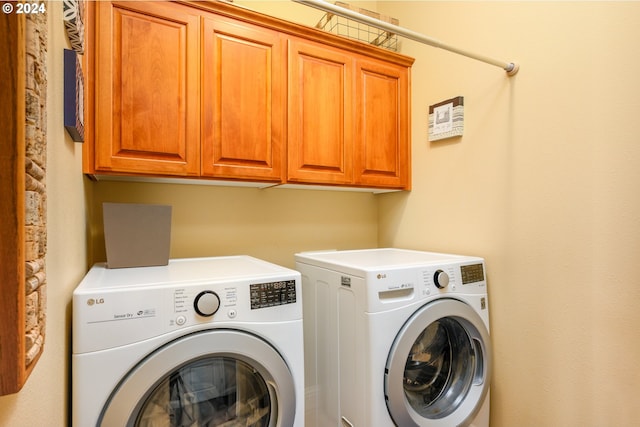 clothes washing area with washer and dryer and cabinets