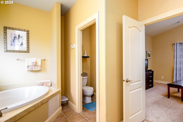 bathroom featuring a bathing tub, toilet, and tile patterned floors