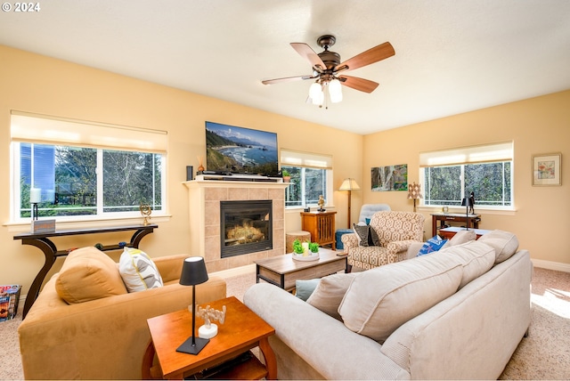 living room with ceiling fan, carpet floors, and a tile fireplace