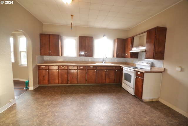 kitchen with white electric stove, a wealth of natural light, and sink