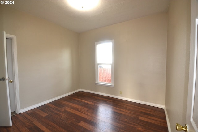 unfurnished room with dark hardwood / wood-style flooring and a textured ceiling