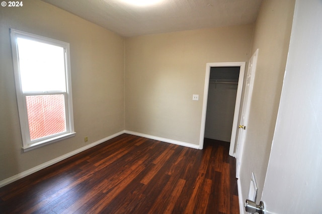 unfurnished room with dark wood-type flooring