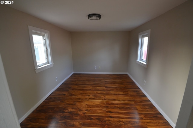 unfurnished room with dark hardwood / wood-style flooring