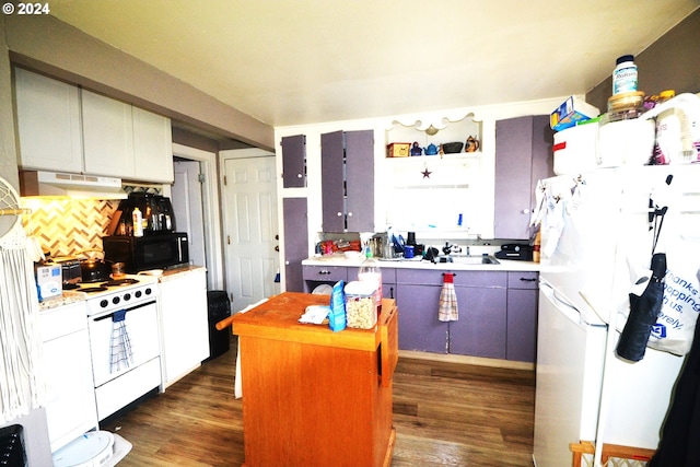 kitchen featuring white cabinets, a kitchen island, dark wood-type flooring, and white appliances