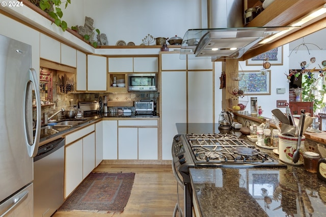 kitchen with backsplash, white cabinetry, appliances with stainless steel finishes, and sink