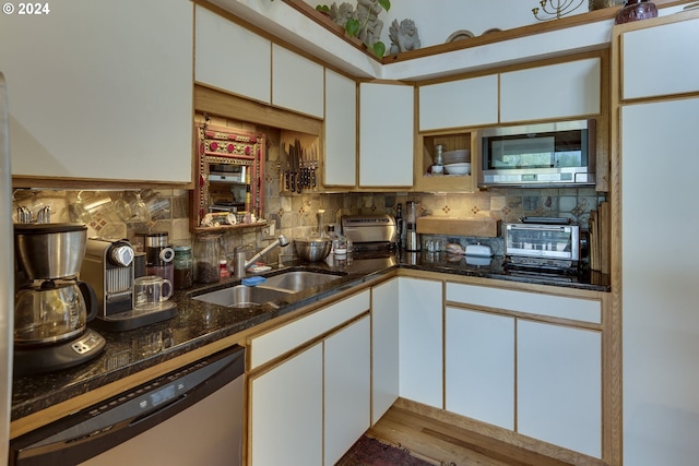 kitchen featuring dishwashing machine, tasteful backsplash, white cabinets, stainless steel microwave, and dark stone countertops