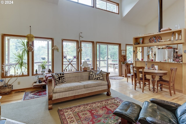 living room with light hardwood / wood-style floors and a towering ceiling