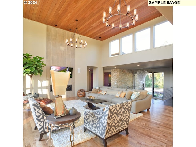 living room with light hardwood / wood-style flooring, a notable chandelier, wooden ceiling, and a high ceiling