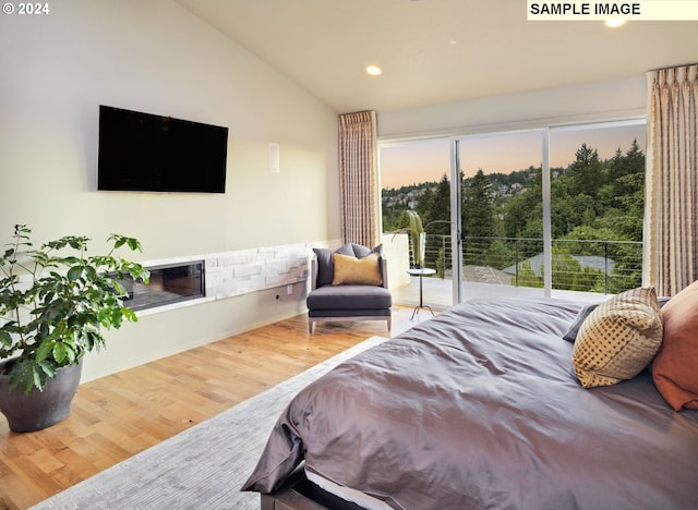 bedroom with access to outside, lofted ceiling, and wood-type flooring