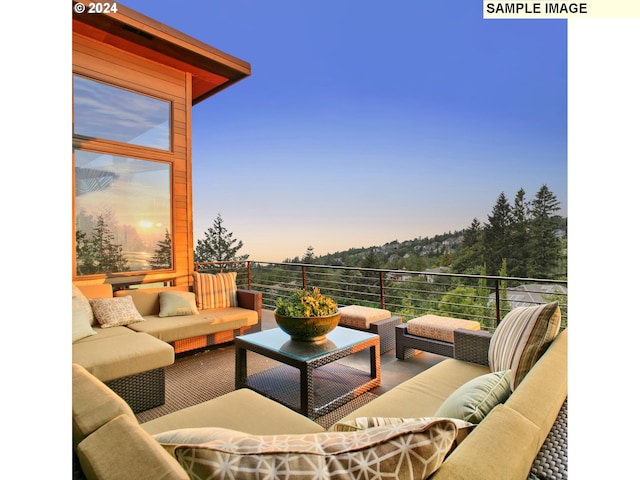 patio terrace at dusk with a balcony and an outdoor living space