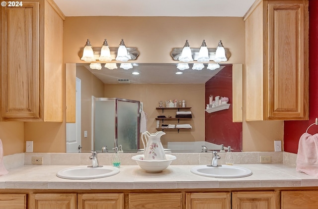 bathroom with double vanity, visible vents, a sink, and a stall shower