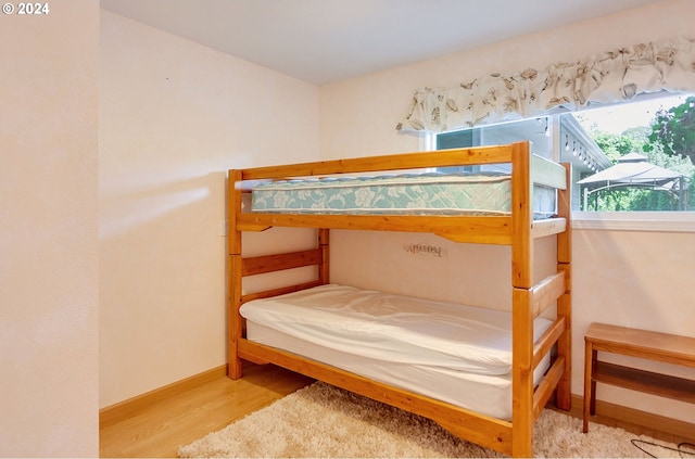 bedroom featuring wood finished floors and baseboards