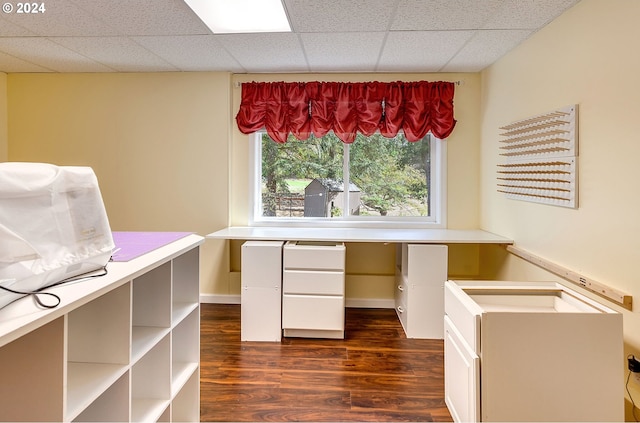 unfurnished office with a drop ceiling and dark wood-type flooring