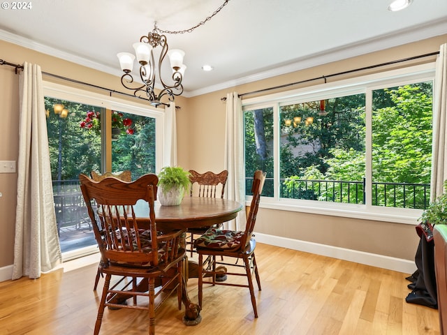 dining room with an inviting chandelier, light wood-type flooring, baseboards, and ornamental molding