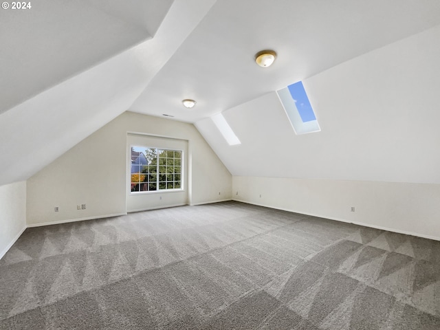 additional living space with lofted ceiling with skylight and carpet flooring