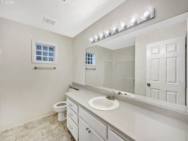 bathroom with vanity, toilet, and walk in shower