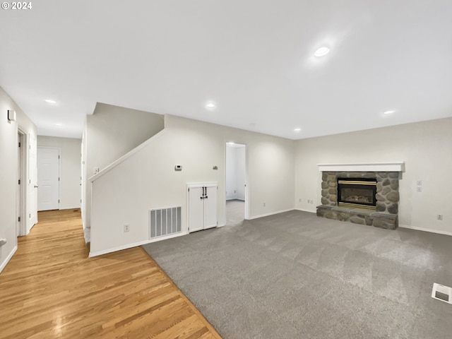 unfurnished living room with a fireplace and light hardwood / wood-style floors