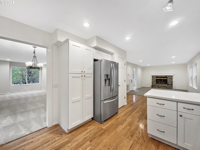 kitchen with stainless steel fridge with ice dispenser, light wood-type flooring, and white cabinets