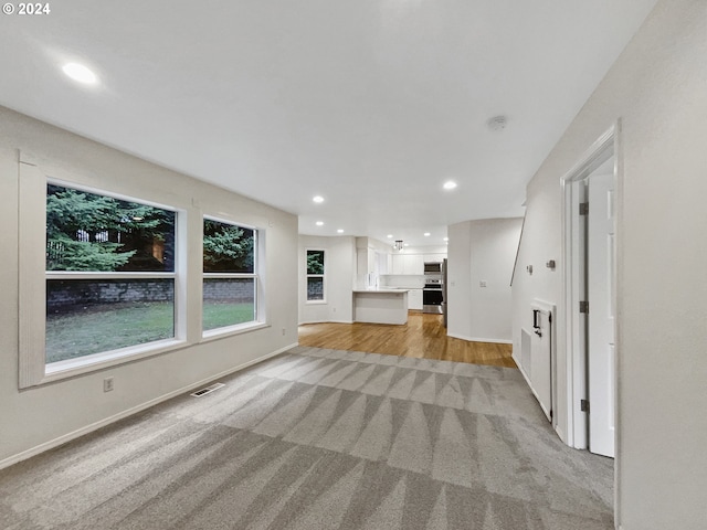 unfurnished living room featuring light colored carpet