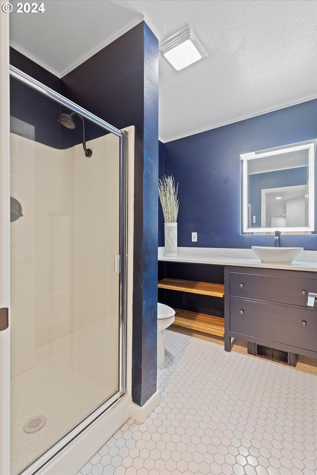 3735 NE Surf Dr, Lincoln City, OR 97367 - bathroom with a stall shower, vanity, toilet, a textured wall, and ornamental molding