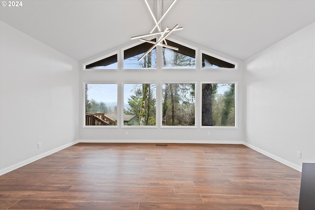 3735 NE Surf Dr, Lincoln City, OR 97367 - spare room featuring plenty of natural light, baseboards, wood finished floors, high vaulted ceiling, and a chandelier