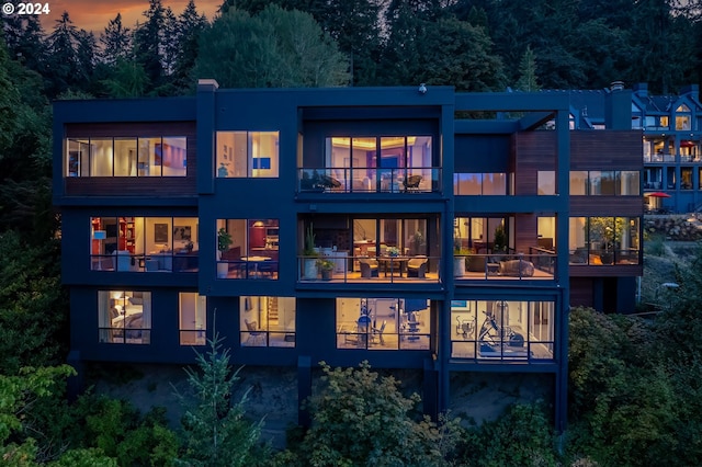 back house at dusk with a balcony