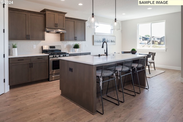 kitchen featuring gas range, sink, dark brown cabinets, and light wood-type flooring