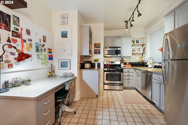 kitchen with gray cabinets, light tile patterned flooring, and stainless steel appliances