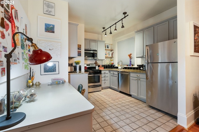 kitchen with gray cabinetry, light tile patterned floors, and stainless steel appliances