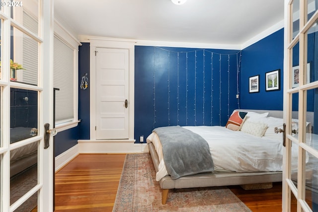 bedroom featuring wood-type flooring, french doors, and crown molding