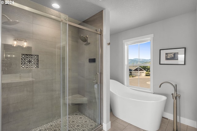 201 Sterling Blvd, White Salmon, WA 98672 - bathroom featuring tile patterned floors, a textured ceiling, a mountain view, a shower stall, and a soaking tub