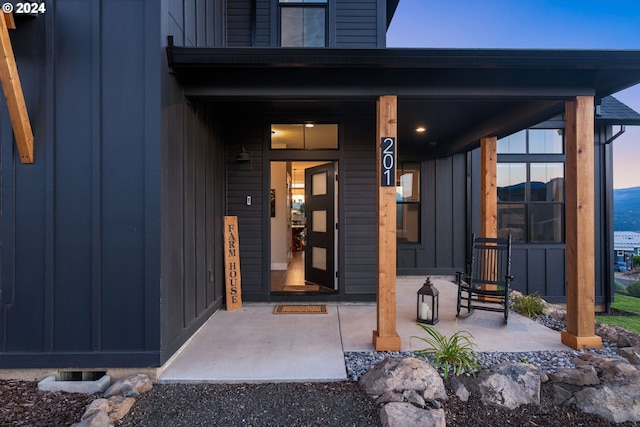 view of exterior entry featuring covered porch