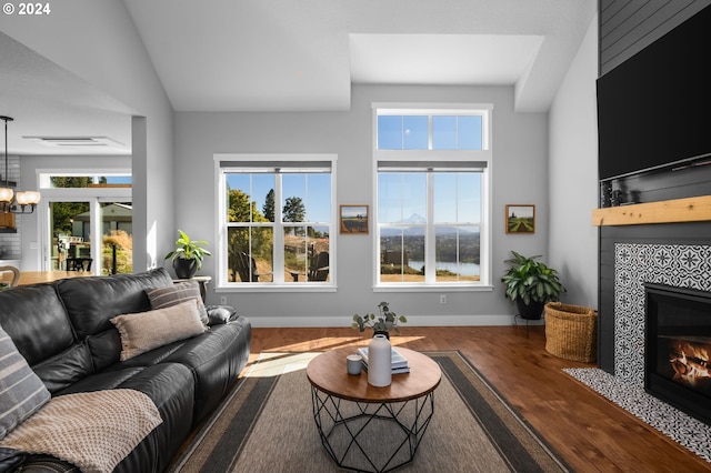 201 Sterling Blvd, White Salmon, WA 98672 - living area with wood finished floors, baseboards, an inviting chandelier, a fireplace, and vaulted ceiling