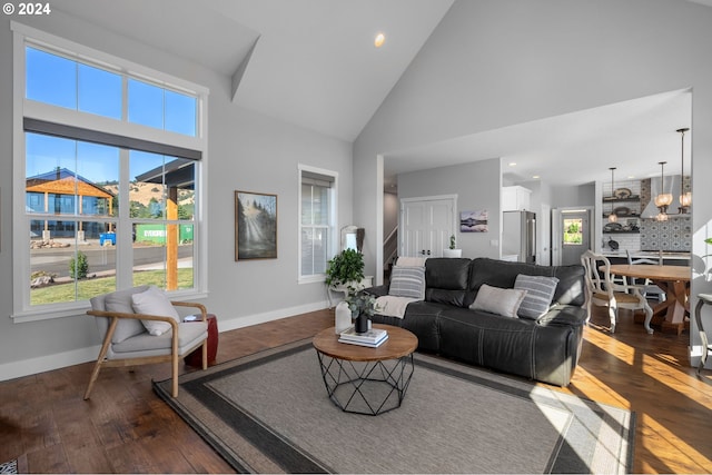 living room featuring dark hardwood / wood-style flooring, high vaulted ceiling, and an inviting chandelier