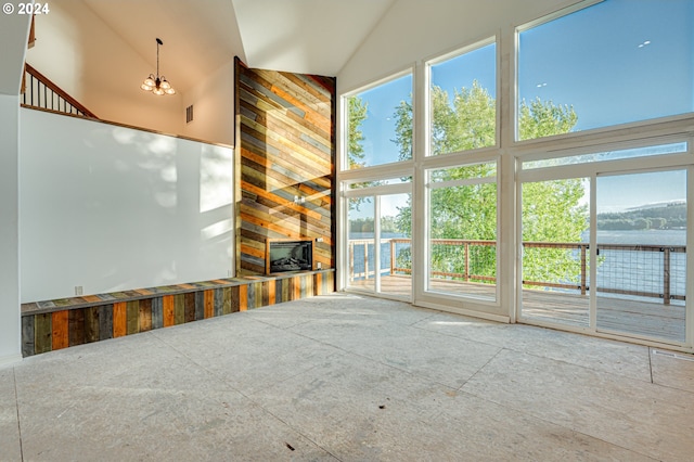 unfurnished living room with a water view and a high ceiling