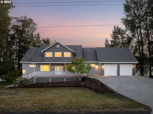 view of front of home with a porch, a garage, and a yard