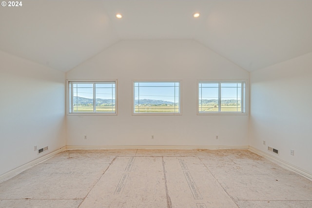 unfurnished room with a healthy amount of sunlight and vaulted ceiling