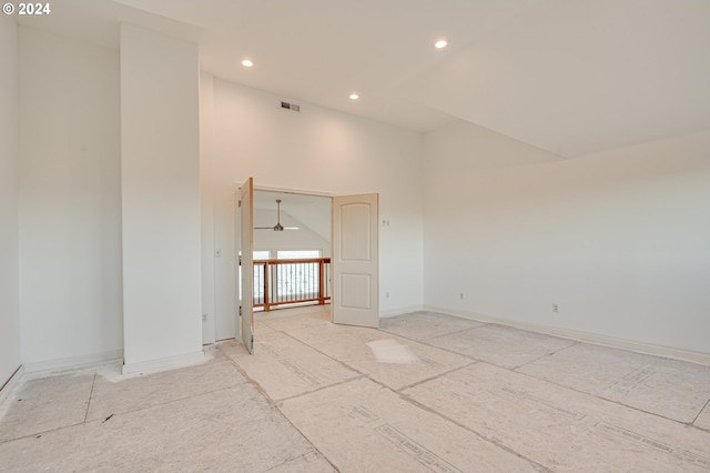 unfurnished room featuring ceiling fan and a high ceiling