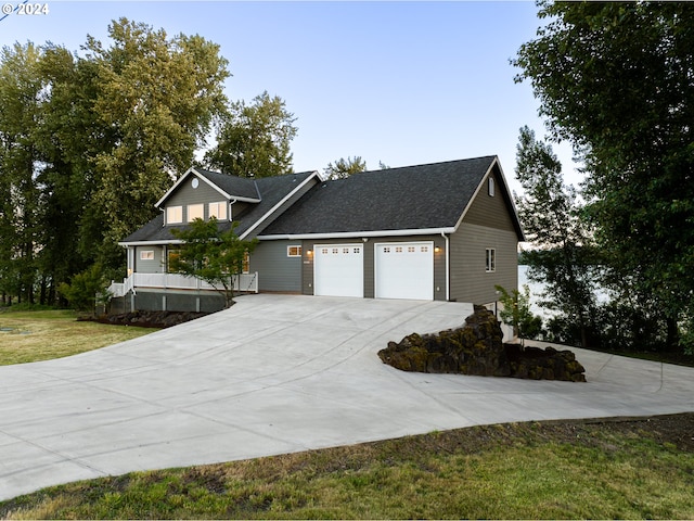 view of front facade with a front lawn, covered porch, and a garage