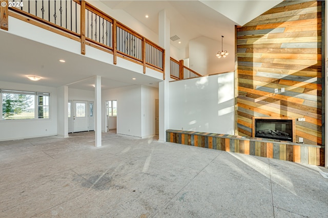 unfurnished living room featuring a chandelier and high vaulted ceiling