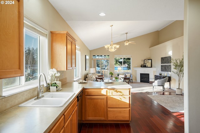 kitchen with kitchen peninsula, vaulted ceiling, plenty of natural light, and sink