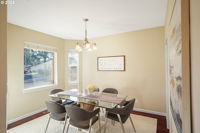 dining room with hardwood / wood-style floors and an inviting chandelier