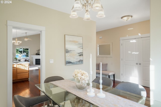 dining room featuring a notable chandelier, dark wood-type flooring, and vaulted ceiling