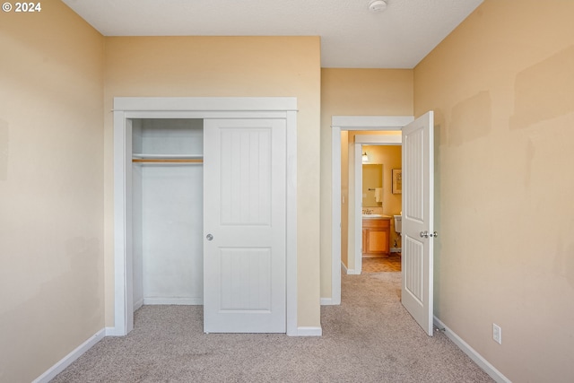 unfurnished bedroom with light carpet and a closet