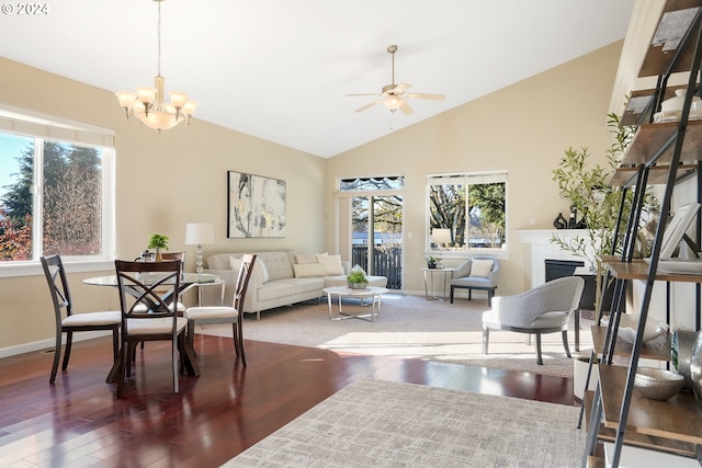 living room with ceiling fan with notable chandelier, dark hardwood / wood-style flooring, and lofted ceiling