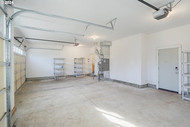 garage featuring heating unit and a garage door opener