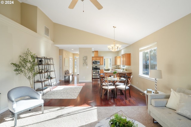 dining room featuring ceiling fan with notable chandelier, dark hardwood / wood-style flooring, and high vaulted ceiling