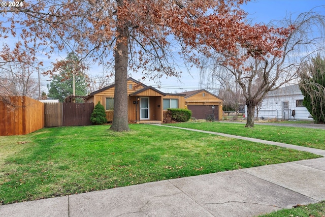 ranch-style home featuring a garage and a front lawn