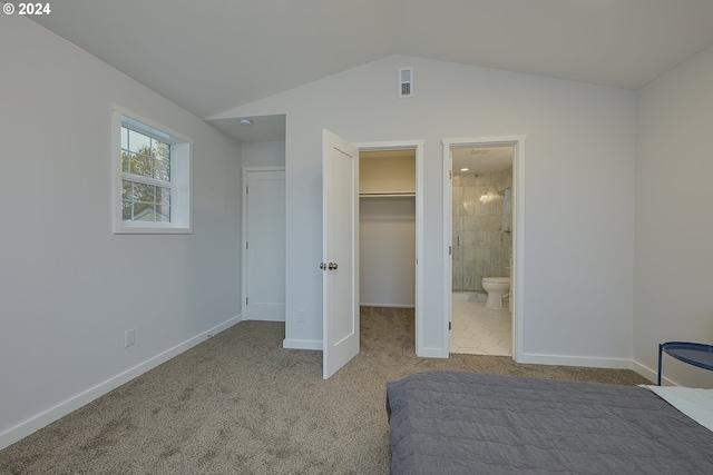 carpeted bedroom with ensuite bath, a spacious closet, a closet, and lofted ceiling