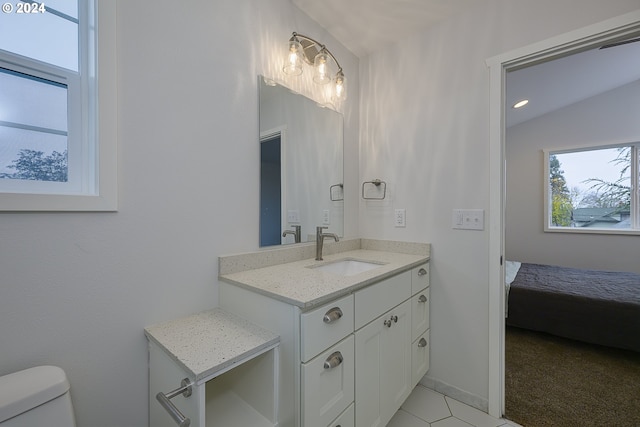 bathroom featuring tile patterned flooring, vanity, toilet, and lofted ceiling